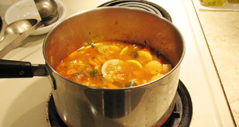 A pot of vegetable soup on a stove.