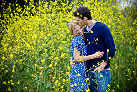Kissing amid lots of yellow flowers